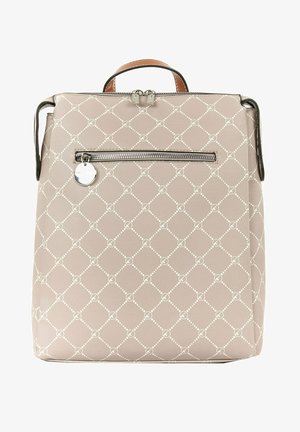 Sac à dos beige à motifs avec une poignée supérieure, une poche zippée horizontale à l'avant et un charm métallique circulaire sur la tirette.