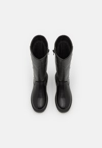 Bottes noires en cuir montant jusqu'au genou, à texture lisse, fermeture éclair latérale et détails décoratifs en métal sur la tige extérieure.