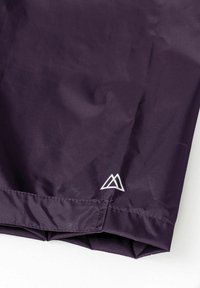 Paarse nylon stof met een gladde textuur, met een wit driehoekig logo in de rechterbenedenhoek. Gestroomlijnd ontwerp, lichtgewicht materiaal.