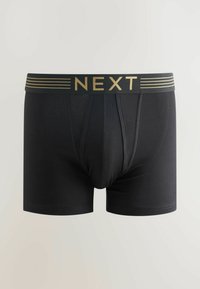 Schwarze Boxershorts mit einem goldgestreiften Bund, der das "NEXT"-Logo trägt. Glatte Textur, enganliegendes Design, mittellange Oberschenkellänge.