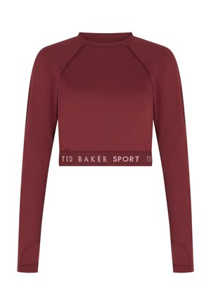 Tumši sarkans īss tops ar garām piedurknēm, izgatavots no gludas auduma. Apakšmalā ir ribots josla ar uzrakstu "TED BAKER SPORT".