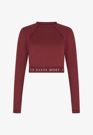Tumši sarkans īss tops ar garām piedurknēm, izgatavots no gludas auduma. Apakšmalā ir ribots josla ar uzrakstu "TED BAKER SPORT".