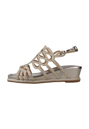 Sandalias de cuña beige con un diseño de tira texturizada, que presenta intrincados recortes y acentos metálicos. Material superior suave y una suela brillante.