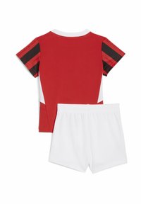 Top atletico rosso con dettagli neri e bianchi e maniche corte, abbinato a pantaloni corti con cintura elastica bianca. Tessuto morbido e traspirante.