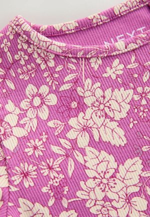 Purple floral-patterned fabric featuring cream-colored flowers, textured ribbed material, and a round neckline with top stitching.