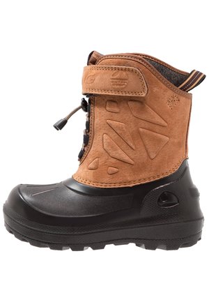 Botte d'hiver pour enfant avec semelle en caoutchouc noire et dessus en daim marron, avec une bride ajustable et une languette à l'arrière.