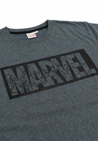 Maglietta Marvel griscia scuro con personaggi contornati in nero come Spider-Man, Iron Man e altri all'interno del logo "MARVEL" in grassetto sulla parte frontale.