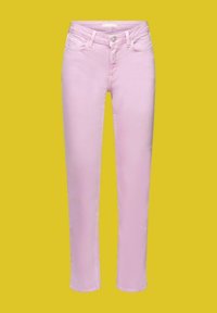 Jean skinny taille haute rose pâle avec bouton à l'avant, fermeture éclair et design à cinq poches sur fond jaune.