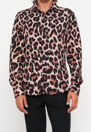 Langärmliges Hemd mit Knopfleiste und beigem, schwarzem und dunkelrotem abstraktem Leopardenmuster, getragen zu einer schwarzen Hose.