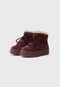 Stivaletti in suede bordeaux con colletto in finta pelliccia beige, punta rotonda e suola piatta testurizzata. Dotati di chiusura con lacci e morbida fodera interna.