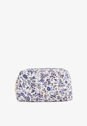 Kreemvärviline lilledega kosmeetikakott sinise lillemustriga, ümar kuju ja kuldne tõmblukk. Omab detailseid botaanilisi illustreerimisi.