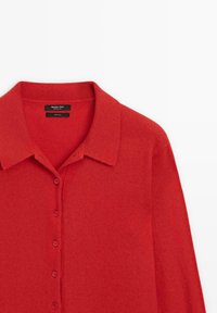 Roter Wollcardigan mit Kragen, Knopfleiste und langen Ärmeln. Glatte Textur mit klassischem Design und ohne sichtbare Muster.