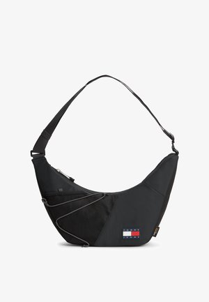 Czarna torebka na ramię z regulowanym paskiem, przednia kieszeń z siateczki z sznurkiem oraz logo Tommy Jeans w dolnym przednim rogu.