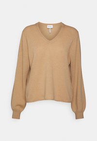 V-neck, pitkähihaiset neulepusero vaaleanbeigeväriä. Pehmeä neuletekstuuri, jossa ribatut hihansuut ja helma. Tunnuksessa lukee "FTC."