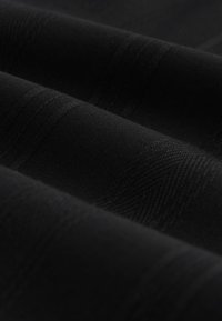 Schwarzer strukturierter Stoff mit dezenten Streifen, der eine glatte und weiche Oberfläche zeigt. Das Material hat einen leichten Glanz und ein gleichmäßiges Webmuster.