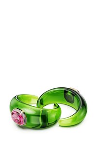 Gröna genomskinliga manschetter av resin, med en stor rosa ädelsten och mindre detaljer, som visar en jämn, blank yta.