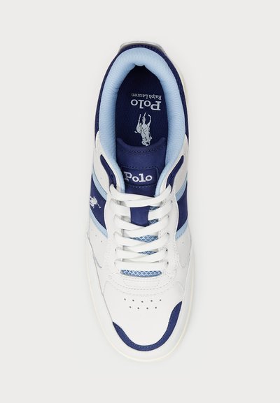 White sneaker with navy and light blue accents, featuring a padded collar, perforated toe, and a textured tongue. Embroidered logo visible.