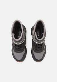 Zapatillas altas en negro y gris que presentan una combinación de materiales suaves y texturizados, cordones y un collar acolchado para mayor comodidad.