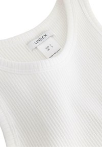 Hvid ribbet tanktop med rund halsudskæring, med et plejemærke der viser størrelserne EUR S og UK 5. Blød tekstur, fremstillet i Bangladesh.