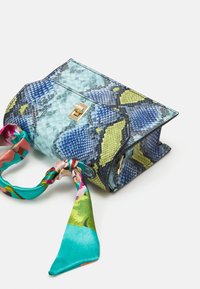 Sac à main en peau de serpent bleu et vert avec une finition brillante, orné d'un foulard en soie décoratif aux couleurs vibrantes attaché à la poignée. Garnitures en or.