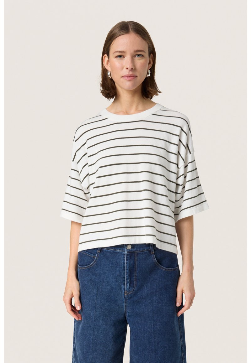 Stripet kortærmet top i hvid og mørkegrøn, lavet af blødt stof, med en bred halsudskæring og løs pasform, parret med blå denimbukser.