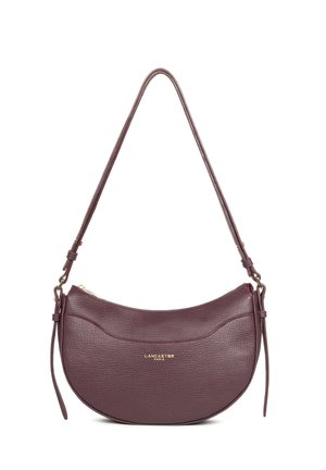 Sac à épaule en cuir violet foncé en forme de demi-lune avec finition texturée, fermeture éclair dorée, bandoulière ajustable et logo "Lancaster Paris" en lettres dorées.