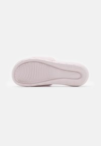 Semelle de chaussure de sport rose clair avec un motif texturé et des bords arrondis, dotée d'un bout rond et d'un léger rembourrage pour le confort.