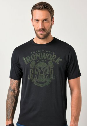 Camiseta de algodón negra con un gráfico frontal de una calavera y herramientas en verde. Mangas cortas y un escote redondo con una textura suave.