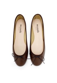 Brown leather ballet flats with a rounded toe, satin bow accent, and tan lining. Smooth texture and minimalistic design.