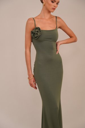 Olive green fitted dress featuring spaghetti straps, a textured flower accent on one shoulder, and ruched side detailing.