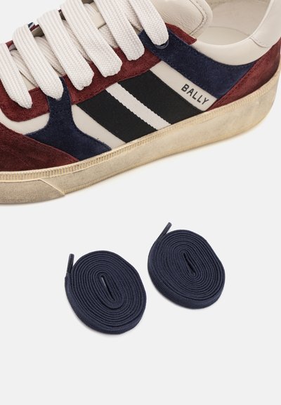 Baskets en cuir et daim blanches, bordeaux et marines avec des rayures noires. Comprend deux lacets enroulés de couleur marine. Design rétro texturé.