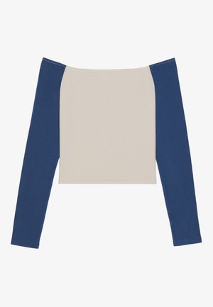 Långärmad topp med en off-white kropp och mörkblå ärmar, med en bred halsringning och en kortad design. Mjuk, slät tygtextur.