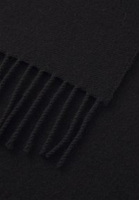 Black scarf made of textured fabric, featuring a fringe detail along one edge. Smooth surface with no visible patterns or accents.