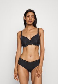 Black underwire bra with smooth fabric and lace trim, paired with matching black lace waistband panties. Both feature delicate accents.