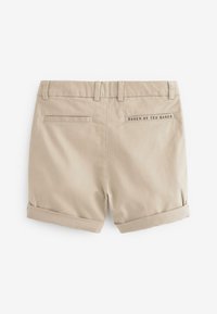 Beige shorts met een omgeslagen zoom, gemaakt van lichtgewicht materiaal. Heeft twee achterzakken en een merklabel met de tekst "BAKER BY TED BAKER."