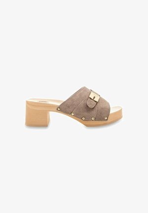 Brown suede heeled mules with a wide strap, gold hardware, and decorative studs. Features a block heel and a smooth light wood sole.