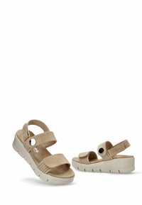 Sandalias beige con parte superior de ante texturizado, correas ajustables y acentos circulares. Presentan una suela ligera y gruesa con surcos para mayor tracción.