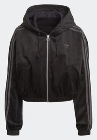 Svart kortad Adidas zip-up hoodie med ribbad textur, dragsko, elastiska ärmmuddar och nederkant, samt tre grå ränder längs ärmarna.