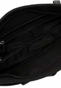 Interno di una borsa a tracolla in pelle nera con molteplici tasche, scomparti con zip, texture liscia e un logo impresso sottile.