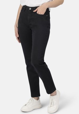 Schwarze Denim-Jeans mit Slim-Fit, Fünf-Taschen-Design und Knopfverschluss. Mit weißen Sneakers für einen Kontrast kombiniert. Glatte Stoffstruktur.