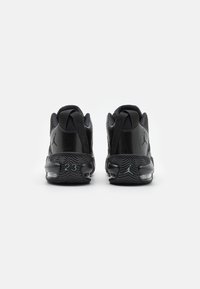 Mustat urheilukengät, joissa on sileä nahkapinta, tekstuuriset yksityiskohdat, ilmastoppi ja erottuva pohja, jossa on numero 23 ja logo.