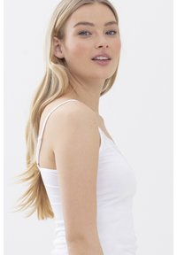 Top bianco in cotone morbido, con spalline sottili e merletto lungo il collo, caratterizzato da una silhouette aderente.