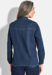 Dunkelblaue Jeanshemd mit langen Ärmeln, spitzem Kragen und Rückeneinsatz-Nahtdetail. Verfügt über Knopfmanschetten und eine taillierte Passform.