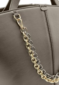 Borsa a mano in pelle grigia con tracolla a catena bicolore in oro e nero, chiusura sicura e finitura testurizzata sulla superficie.