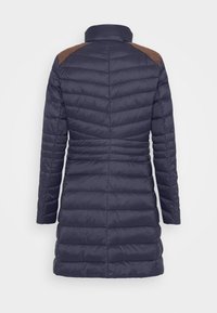 Navy Pufferjacke mit hohem Kragen, horizontal gestepptem Design, leichtem Material und kontrastierenden braunen Lederakzenten an den Schultern.
