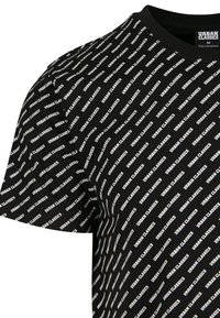 Schwarzes T-Shirt mit Rundhalsausschnitt, versehen mit einem weißen diagonalen Textmuster "URBAN CLASSICS" und einem sichtbaren Größenetikett "M" im Kragen.