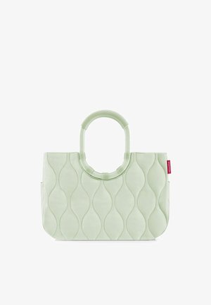 Borsa tote trapuntata verde chiaro con motivo cucito ondulato, manici circolari e una piccola etichetta rossa sul lato destro.