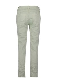 Pantalon slim vert clair vu de dos avec deux poches arrière et des détails cousus près de la taille.