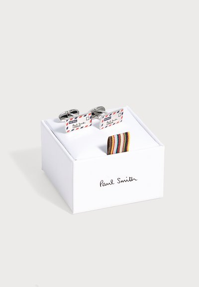 Paire de boutons de manchette rectangulaires en argent avec design d'enveloppe de courrier aérien présentée sur une boîte blanche de marque Paul Smith avec un onglet rayé coloré.