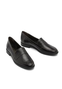 Mocassins noirs en cuir avec une finition lisse, présentant une couture, un design à enfiler et un accent rectangulaire sur le devant.